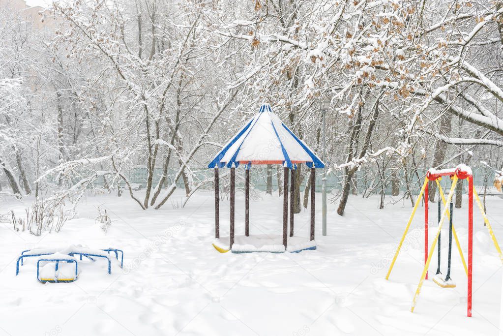 Snowy playground in winter, Moscow, Russia. Empty urban park during snowfall. Scenery of the kindergarten in the winter city.