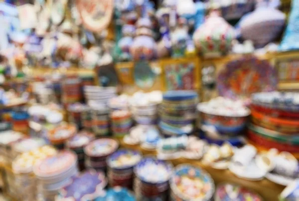 Eastern ceramics in the Grand Bazaar as creative abstract blur background, Istanbul, Turkey. This old bazaar or Kapali Carsi is a famous landmark of Istanbul. Painted pottery in the oriental bazaar.
