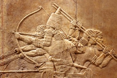 Assyrian relief on the wall. Ancient carving on the stone from Middle East history close-up. Remains of the culture of ancient civilization. Assyrian and Sumerian art for vintage background. clipart
