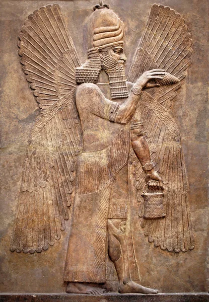 亚述人的墙浮雕了一个有翅膀的天才 中东历史上古老的雕刻板 古代亚述和苏美尔文明文化的遗迹 美索不达米亚艺术 — 图库照片