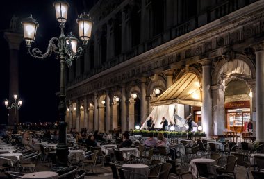Venice, İtalya - 19 Mayıs 2017: Müzikal grup San Marco üzerinde açık restorandaki geceleri kare oynayan. Venedik'te romantik akşam. San Marco Venedik ana turistik 's.