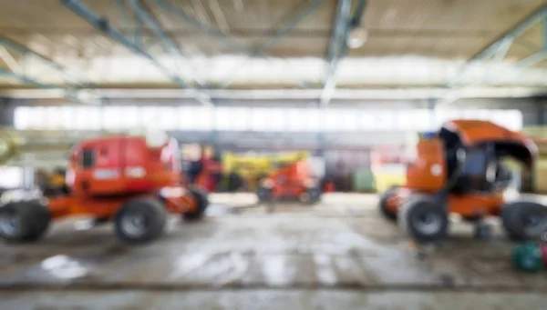 Construction machinery in garage as creative abstract blur backg — Stock Photo, Image