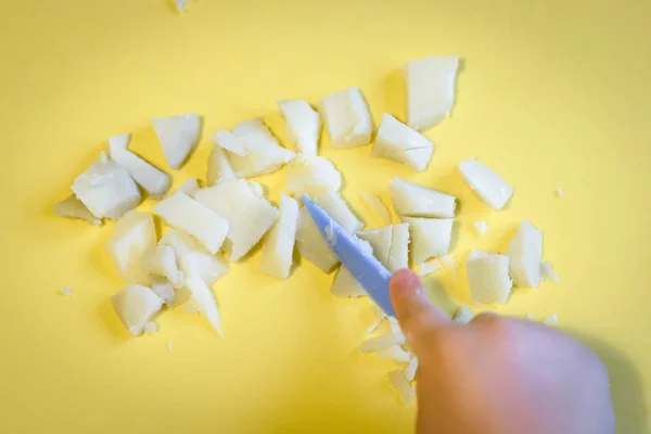 Kid cuts with a toy knife potatoes in kitchen — Stock Photo, Image