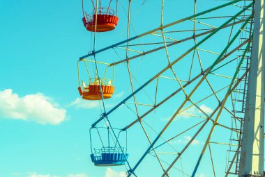 Mavi gökyüzü arka plan üzerinde renkli kabin ile dönme dolap