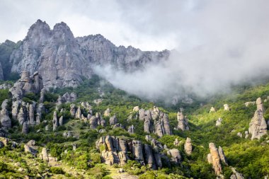 Sis ile kaplı dağ manzarası, Kırım. Sisli Demerdji Dağı 'nın Hayaletleri Vadisi. Burası Kırım 'ın doğal bir turistik cazibesi. Sis veya alçak bulutlardaki tuhaf kayaların manzarası.