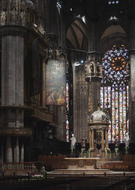 Milan, İtalya - 16 Mayıs 2017: Milan Katedrali veya Duomo di Milano 'nun İçi. Meşhur Katolik kilisesi, Milano 'nun en önemli simgesidir. Karanlık Gotik katedralin içinde, süslü sunağın dikey görüntüsü.