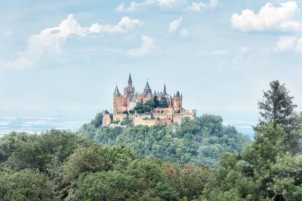 Landscape of misty mountain with Gothic Hohenzollern Castle in summer morning, Germany. Old Burg Hohenzollern is landmark in Stuttgart vicinity. Scenic view of fairytale German castle like palace.