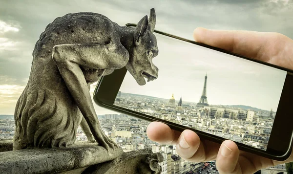 ノートルダム大聖堂のガーゴイルパリは 携帯電話や携帯電話 フランスでエッフェル塔を見ています 古いパリとスマートフォンの面白い写真 技術の概念 — ストック写真