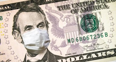 ABD 'de Coronavirus, 5 dolarlık banknotta yüz maskesi olan Başkan Lincoln. COVID-19 küresel borsayı etkiledi. Ekonomi, Corona virüsü salgınıyla sarsıldı. Kriz, durgunluk ve finans kavramı.