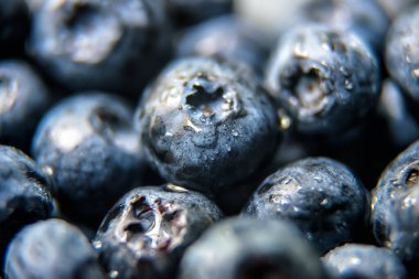 Yaban mersinli arkaplan, yaban mersinli ya da yaban mersinli. Bir sürü yabanmersini deseni, doğadaki yabanmersini hasadı. Bolluk ve taze yiyecek kavramı. Makro görünüm, seçici odak.