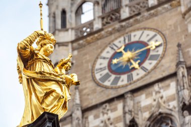 Marienplatz Meydanı, Münih, Almanya 'da Bakire Meryem heykeli. Burası Münih 'in bir numaralı simgesidir. Münih şehir merkezindeki belediye binasının arka planında Mariensaule sütunu üzerinde altın heykel.