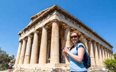 Antik Agora 'daki Hephaestus Tapınağı, Atina, Yunanistan. Burası Atina 'nın turistik merkezi. Atina merkezindeki klasik Yunan binasının fotoğraflarını çeken kadın. Seyahat ve tatil kavramı
