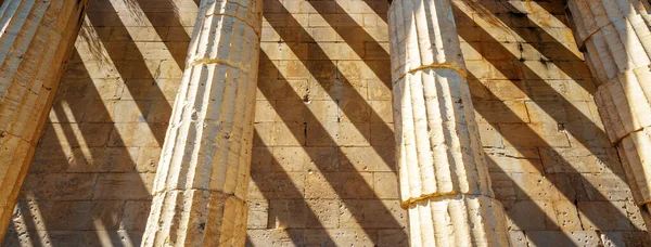Shadow strips on stone wall of old Hephaestus Temple, Athens, Greece. This Ancient Greek building is landmark of Athens. Panoramic view of classical architecture detail. Masonry and history concept.