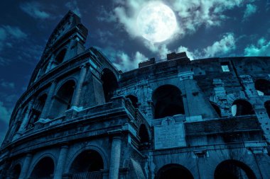 Kolezyum geceleri, Roma, İtalya. Antik Kolezyum 'un dolunaydaki esrarengiz görüntüsü. Roma şehir merkezinde mavi ışıkla ünlü ürkütücü, karanlık bir sahne. Tarih, Cadılar Bayramı ve korku konsepti.