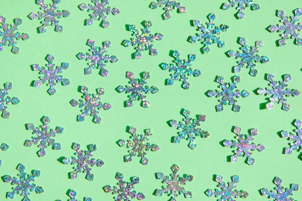 Lamina olografica fiocchi di neve confetti sparse sul colore alla moda menta — Foto Stock