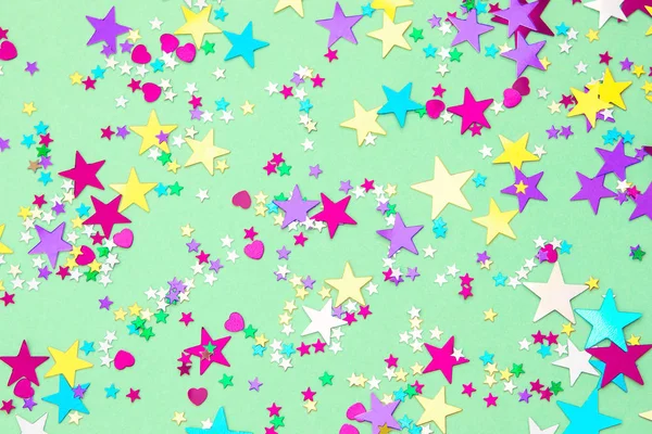 Colorful foil stars confetti sparse on trendy mint colored backg — Stock Photo, Image