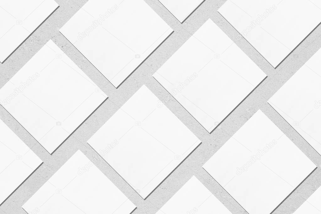 white square business card mockups lying diagonally on grey conc