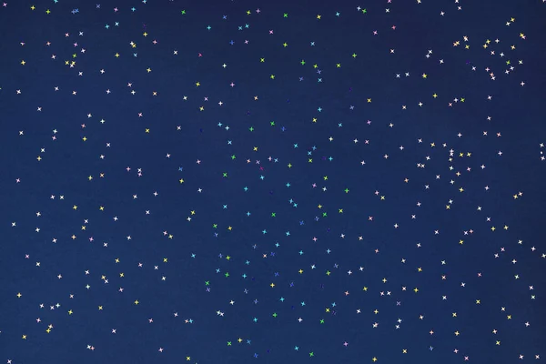 Конфетти из голографической фольги разлетаются на темно-синей спине — стоковое фото