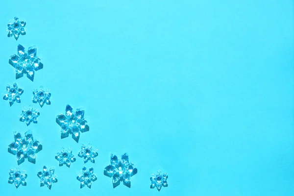 Copos de nieve decorativos en la luz del sol brillante en ba azul claro de moda —  Fotos de Stock