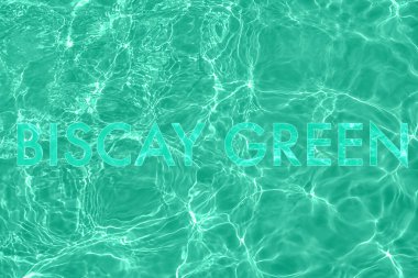 mint colored lettering on calm clear water surface