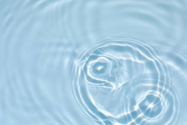 Bulanık mavi, berrak, durgun su yüzeyi dokusu sıçrama ve kabarcıklarla kaplı. Moda soyut doğa geçmişi. Güneş ışığı altında su dalgaları kopyalama alanı ile.