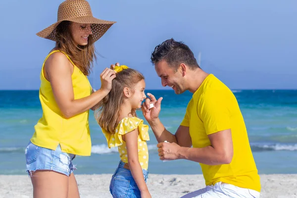 Famille heureuse avec crème solaire en vacances — Photo