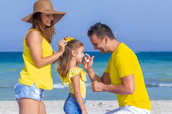Famiglia felice con crema solare in vacanza Fotografia Stock