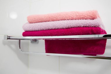 Metal bir rafta çok renkli havlu yığını. Yatay.