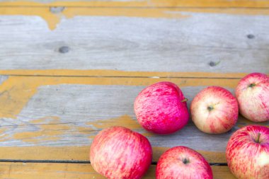 Taze kırmızı elmalar ahşap bir yüzeyüzerinde uzanır. Yatay.