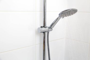   Beyaz kiremit üzerinde Krom duş. Yatay, Dikey.