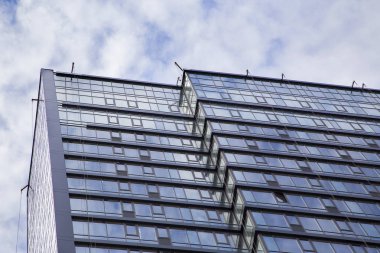 Cam ve betondan yapılmış modern bir ofis binasının cephesi.