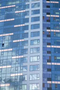 Cam ve betondan yapılmış modern bir ofis binasının cephesi.