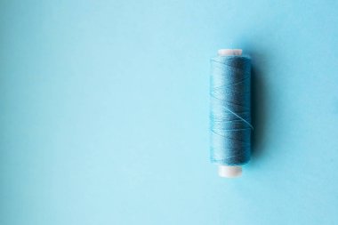 Pembe mavi arka plan üzerinde renkli iplik bobinleri. Dikiş malzemeleri ve aksesuarlar, dikiş, dikiş, nakış. metin için yer. düz yatıyordu, en iyi görünümü 