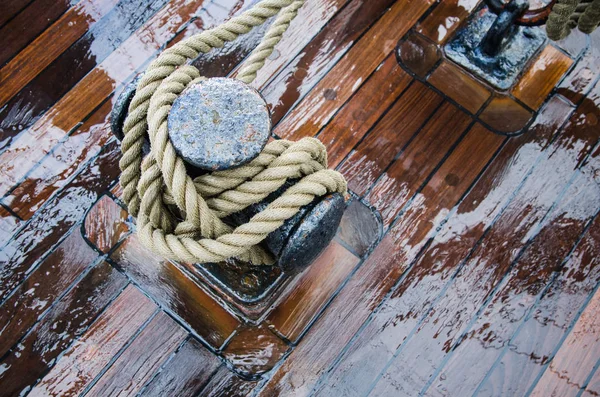 Bollard with a rope on the wooden deck of a sailing vessel, clos — Stock Photo, Image