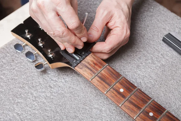 the master sets up the guitar neck anchor