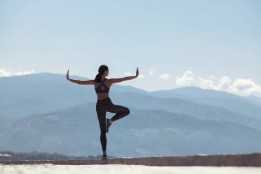 Karşı dağlar deniz kenarında sahildeki sabah yoga yaparken kız.