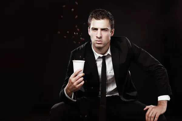 残忍的家伙穿着黑色西装喝咖啡咖啡豆 黑色背景 和你一起喝咖啡 — 图库照片