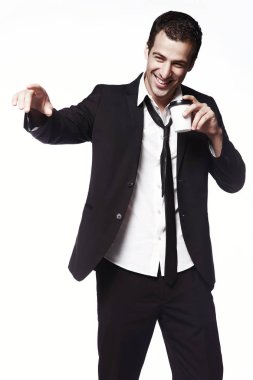 Bir kahve fincanı beyaz bir arka plan üzerinde siyah elbiseli Genç bir adam bir el hareketi yapar. Reklam, yaratıcılık. Kahve.