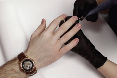 Manikür salonunda prosedür de adam. Spa, manikür, ana işlemleri öğütücü çivi. Güzel erkek elleri.