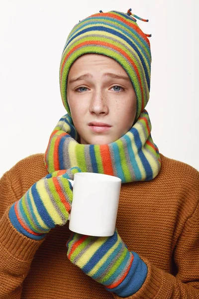 病気の少年はお茶を飲み 薬を飲み 病気になった セーターでは キャップ インフルエンザ スタジオの白い背景で — ストック写真