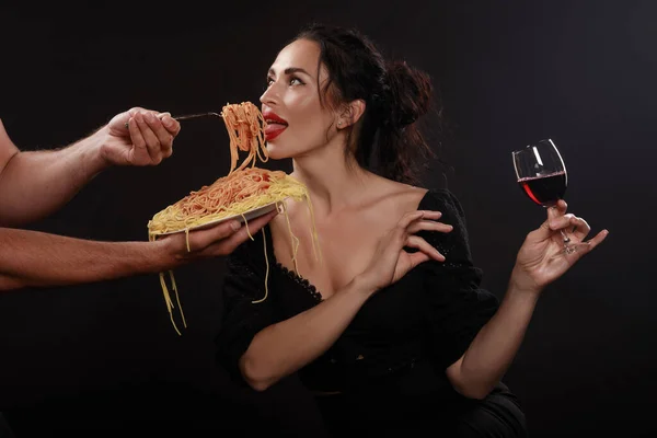Красивая девушка ест спагетти и пьет вино — стоковое фото