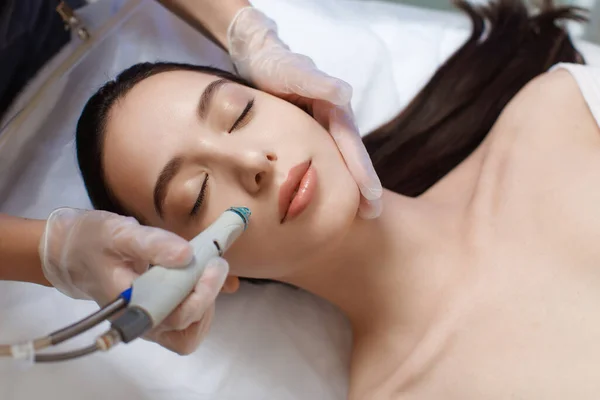 Professional female cosmetologist doing hydrafacial procedure in Cosmetology clinic. — Stock Photo, Image