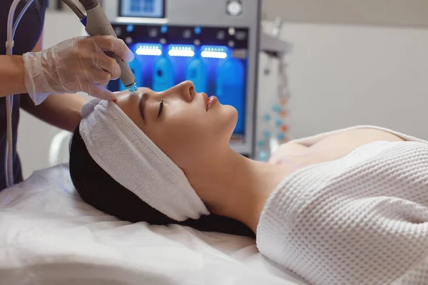 Vista lateral da mulher recebendo terapia de microdermoabrasão na testa no spa de beleza — Fotografia de Stock