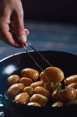 Haşlanmış taze patates, yağlı ve kavrulmuş sarımsak, ahşap bir tabakta..