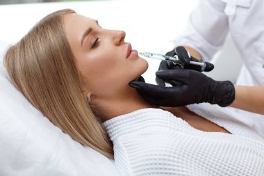 Büyüyen dudaklar, dudak düzeltme. Yüzü kırışıklıklarla dolu bir ameliyat sırasında beyaz kadın portresi.