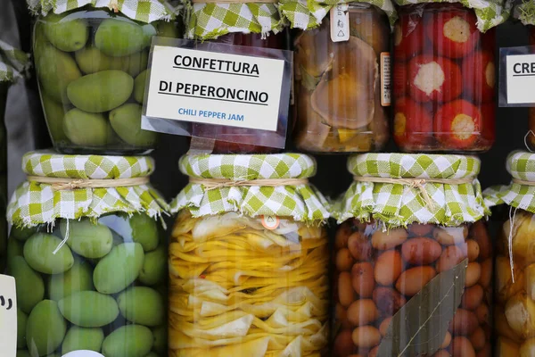 Farklı türde ev yapımı turşulu Rustik kavanozlar. Konserve enginar ve zeytin çok yakın bir plan. Kavanozlarda çeşitli sebzeler var. Kontrol edilmiş kumaşlı cam kavanozlar, dekoratif kaba ip ve aynı beyaz ve yeşil c 'ye sahip.