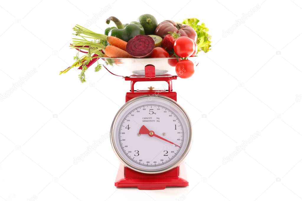 close-up photo of raw vegetables on scale, diet food concept