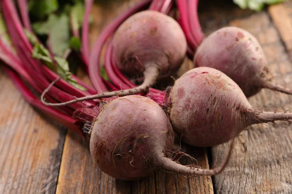 木桌上的 Beetroots 和叶子 — 图库照片