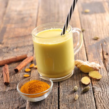 Altın süt, sütlü kahve d'or ahşap arka plan üzerinde