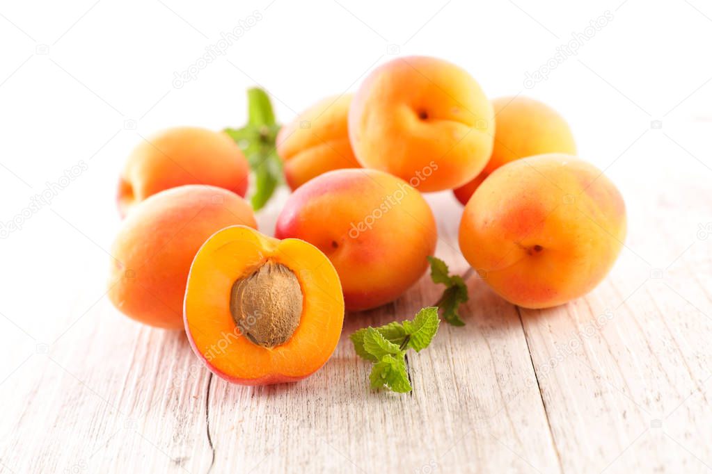fresh apricots and mint on wooden table background
